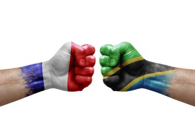 Two hands punch to each others on white background. Country flags painted fists, conflict crisis concept between france and tanzania
