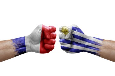 Two hands punch to each others on white background. Country flags painted fists, conflict crisis concept between france and uruguay