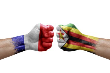 Two hands punch to each others on white background. Country flags painted fists, conflict crisis concept between france and zimbabwe