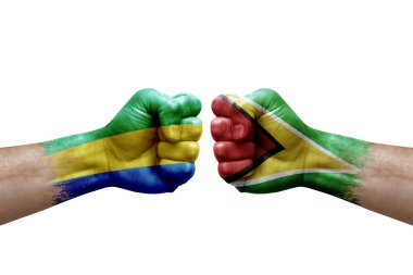 Two hands punch to each others on white background. Country flags painted fists, conflict crisis concept between gabon and guyana