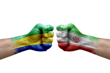 Two hands punch to each others on white background. Country flags painted fists, conflict crisis concept between gabon and iran