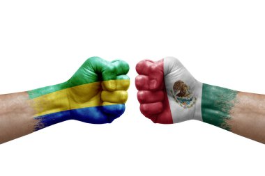 Two hands punch to each others on white background. Country flags painted fists, conflict crisis concept between gabon and mexico