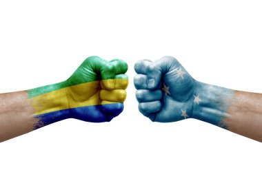 Two hands punch to each others on white background. Country flags painted fists, conflict crisis concept between gabon and micronesia