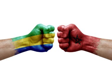 Two hands punch to each others on white background. Country flags painted fists, conflict crisis concept between gabon and morocco