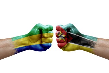 Two hands punch to each others on white background. Country flags painted fists, conflict crisis concept between gabon and mozambique