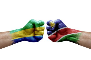 Two hands punch to each others on white background. Country flags painted fists, conflict crisis concept between gabon and namibia