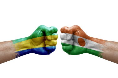 Two hands punch to each others on white background. Country flags painted fists, conflict crisis concept between gabon and niger