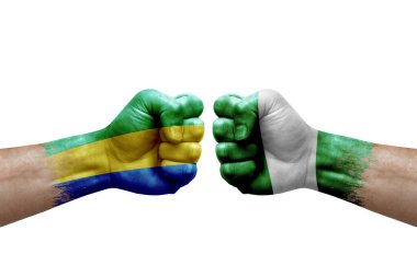 Two hands punch to each others on white background. Country flags painted fists, conflict crisis concept between gabon and nigeria