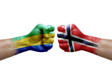 Two hands punch to each others on white background. Country flags painted fists, conflict crisis concept between gabon and norway