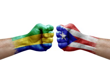 Two hands punch to each others on white background. Country flags painted fists, conflict crisis concept between gabon and puerto rico
