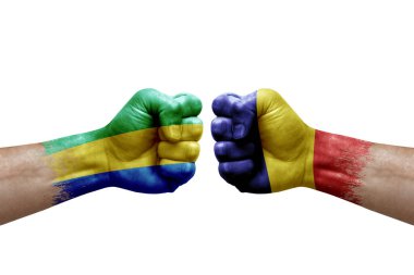 Two hands punch to each others on white background. Country flags painted fists, conflict crisis concept between gabon and romania