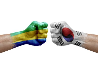 Two hands punch to each others on white background. Country flags painted fists, conflict crisis concept between gabon and south korea