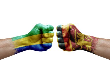Two hands punch to each others on white background. Country flags painted fists, conflict crisis concept between gabon and sri lanka