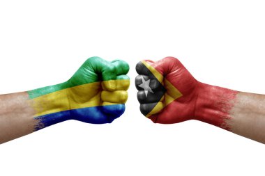 Two hands punch to each others on white background. Country flags painted fists, conflict crisis concept between gabon and timor leste