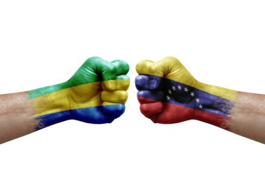 Two hands punch to each others on white background. Country flags painted fists, conflict crisis concept between gabon and venezuela