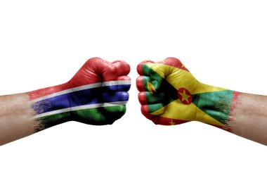 Two hands punch to each others on white background. Country flags painted fists, conflict crisis concept between gambia and grenada