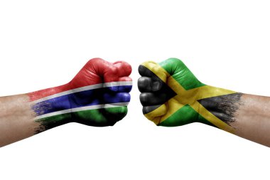 Two hands punch to each others on white background. Country flags painted fists, conflict crisis concept between gambia and jamaica