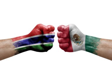 Two hands punch to each others on white background. Country flags painted fists, conflict crisis concept between gambia and mexico