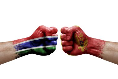 Two hands punch to each others on white background. Country flags painted fists, conflict crisis concept between gambia and montenegro