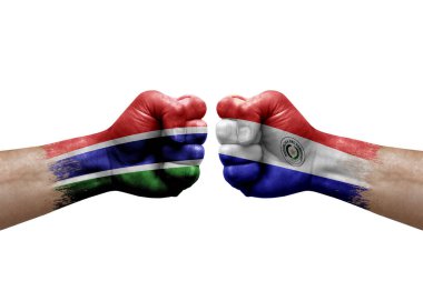 Two hands punch to each others on white background. Country flags painted fists, conflict crisis concept between gambia and paraguay