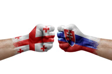 Two hands punch to each others on white background. Country flags painted fists, conflict crisis concept between georgia and slovakia
