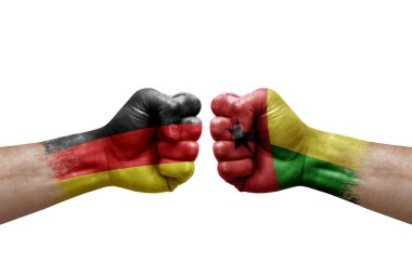 Two hands punch to each others on white background. Country flags painted fists, conflict crisis concept between germany and guinea-bissau
