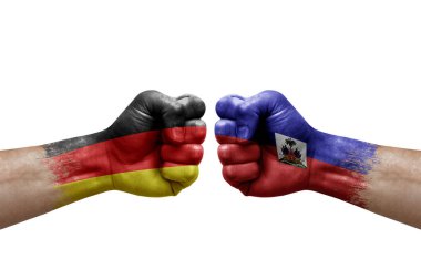 Two hands punch to each others on white background. Country flags painted fists, conflict crisis concept between germany and haiti