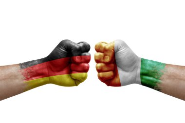 Two hands punch to each others on white background. Country flags painted fists, conflict crisis concept between germany and ivory coast