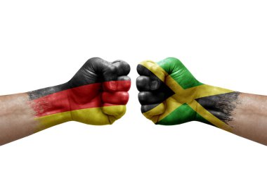 Two hands punch to each others on white background. Country flags painted fists, conflict crisis concept between germany and jamaica