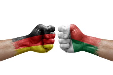 Two hands punch to each others on white background. Country flags painted fists, conflict crisis concept between germany and madagascar
