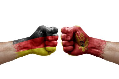 Two hands punch to each others on white background. Country flags painted fists, conflict crisis concept between germany and montenegro