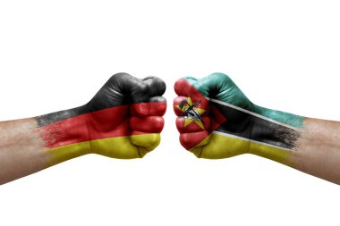 Two hands punch to each others on white background. Country flags painted fists, conflict crisis concept between germany and mozambique