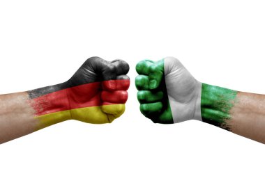Two hands punch to each others on white background. Country flags painted fists, conflict crisis concept between germany and nigeria