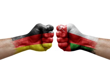 Two hands punch to each others on white background. Country flags painted fists, conflict crisis concept between germany and oman