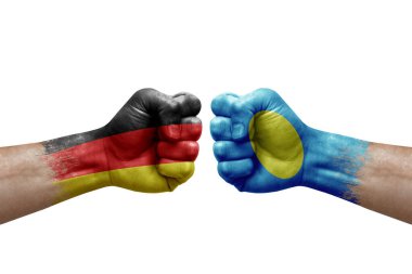 Two hands punch to each others on white background. Country flags painted fists, conflict crisis concept between germany and palau