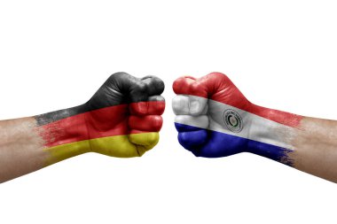 Two hands punch to each others on white background. Country flags painted fists, conflict crisis concept between germany and paraguay