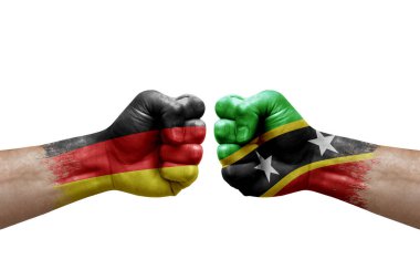 Two hands punch to each others on white background. Country flags painted fists, conflict crisis concept between germany and saint kitts and nevis