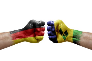 Two hands punch to each others on white background. Country flags painted fists, conflict crisis concept between germany and saint vincent and the grenadines