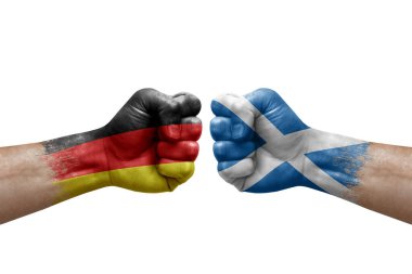 Two hands punch to each others on white background. Country flags painted fists, conflict crisis concept between germany and scotland