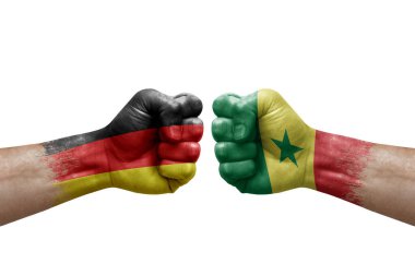 Two hands punch to each others on white background. Country flags painted fists, conflict crisis concept between germany and senegal