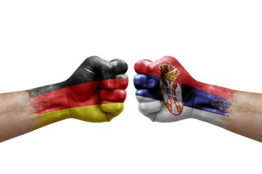 Two hands punch to each others on white background. Country flags painted fists, conflict crisis concept between germany and serbia