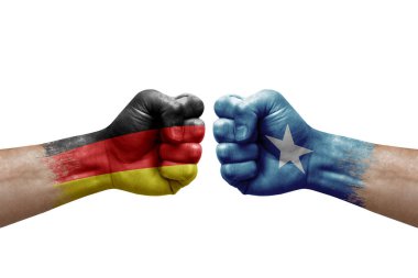 Two hands punch to each others on white background. Country flags painted fists, conflict crisis concept between germany and somalia