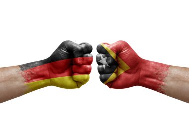 Two hands punch to each others on white background. Country flags painted fists, conflict crisis concept between germany and timor leste