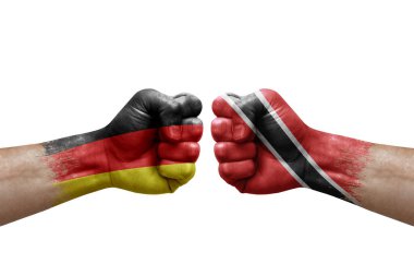 Two hands punch to each others on white background. Country flags painted fists, conflict crisis concept between germany and tobago