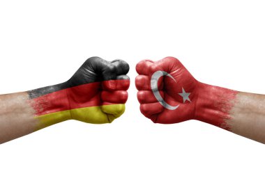Two hands punch to each others on white background. Country flags painted fists, conflict crisis concept between germany and turkey