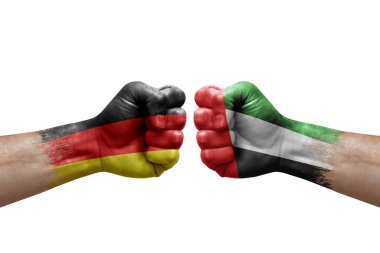 Two hands punch to each others on white background. Country flags painted fists, conflict crisis concept between germany and united arab emirates