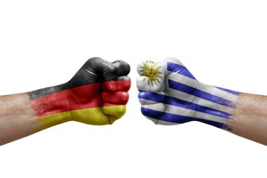 Two hands punch to each others on white background. Country flags painted fists, conflict crisis concept between germany and uruguay