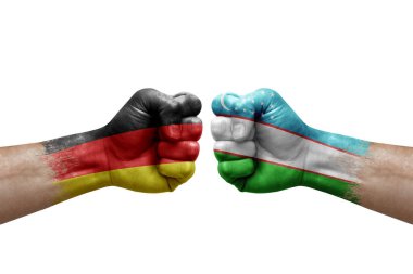 Two hands punch to each others on white background. Country flags painted fists, conflict crisis concept between germany and uzbekistan