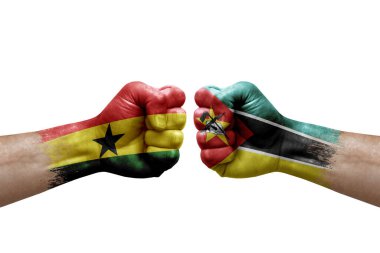 Two hands punch to each others on white background. Country flags painted fists, conflict crisis concept between ghana and mozambique