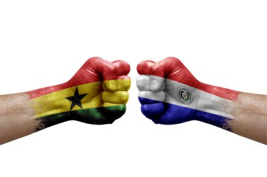 Two hands punch to each others on white background. Country flags painted fists, conflict crisis concept between ghana and paraguay